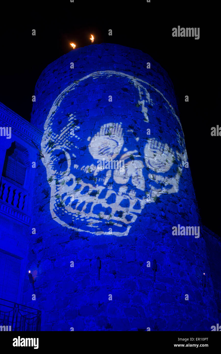 Light projection of a skull over medieval city as part of the feast setup. Stock Photo