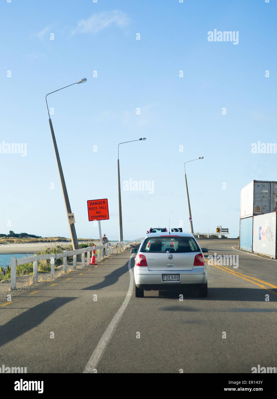 Earthquake damage on a coastal road in Christchurch New Zealand with tilting lamp posts Stock Photo