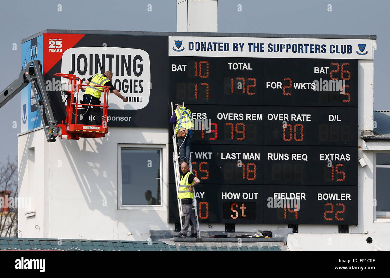 Workmen get a birds eye view of the match from the scoreboard during a pre season friendly match between Sussex and Surrey at the Brightonandhovejobs.com County Ground in Hove. April 8 2015 James Boardman / TELEPHOTO IMAGES 07967642437 Stock Photo