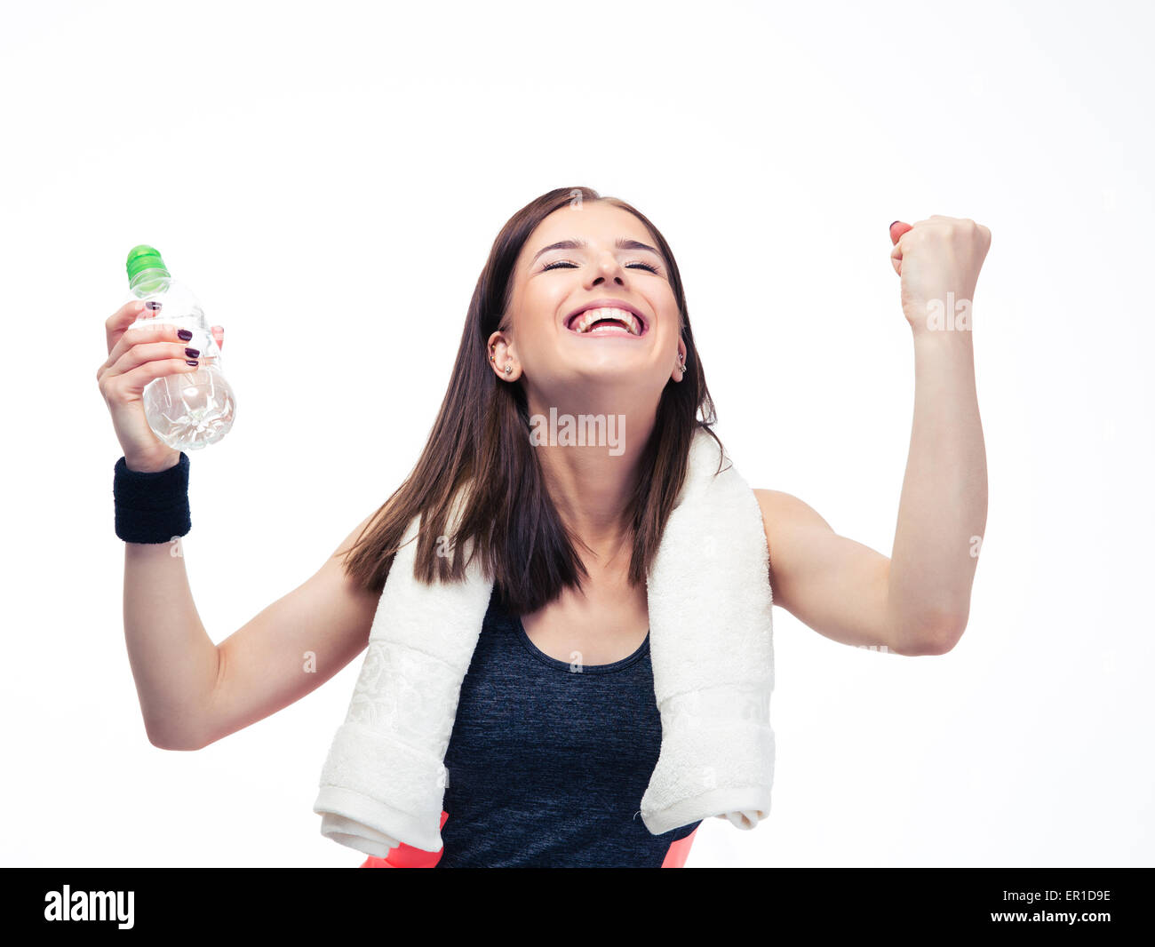 Fitness woman with towel holding bottle with water and celebrating her ...