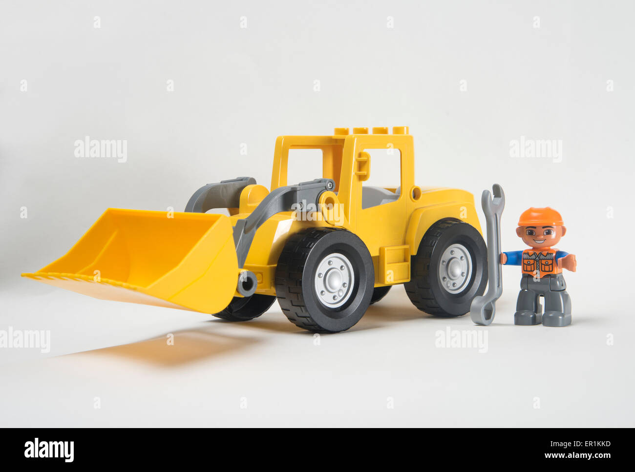Man at work. Lego Duplo front loader digger with driver holding spanner Stock Photo