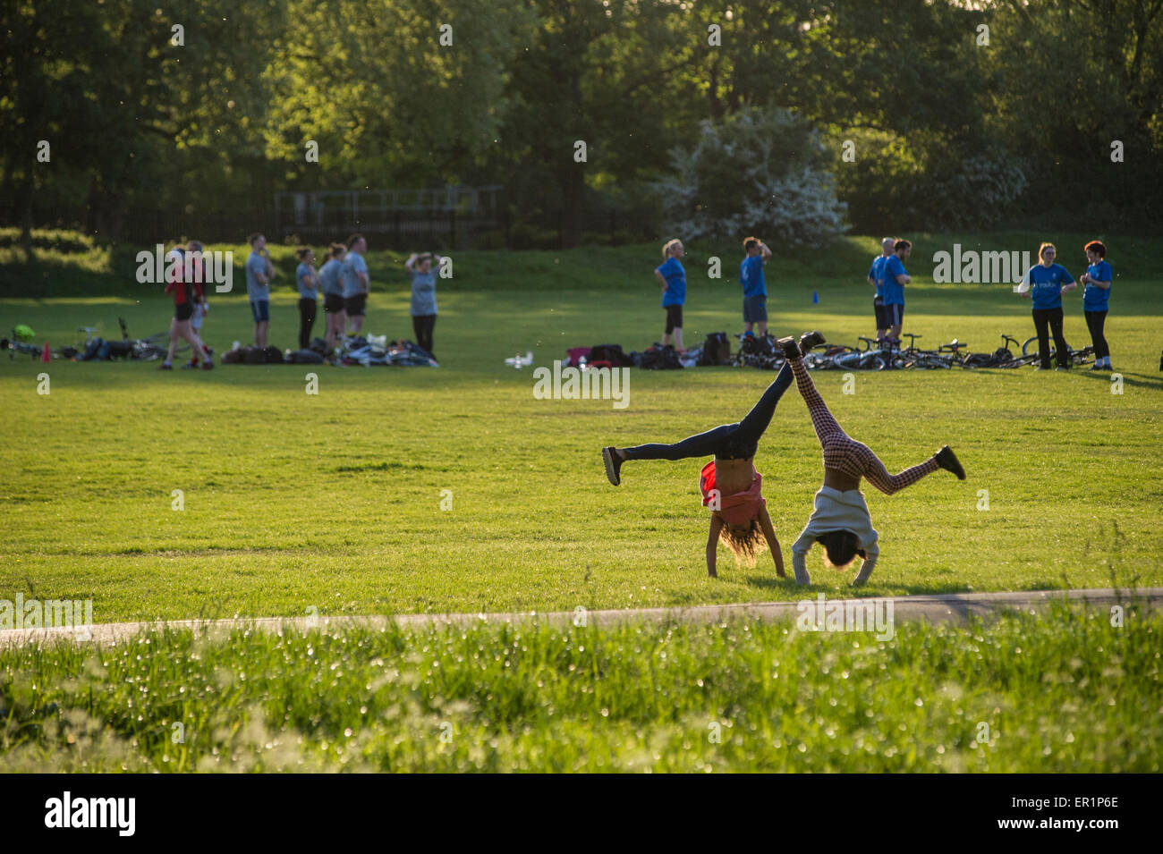 Two girls cartwheel on a summer's day in a London parl Stock Photo