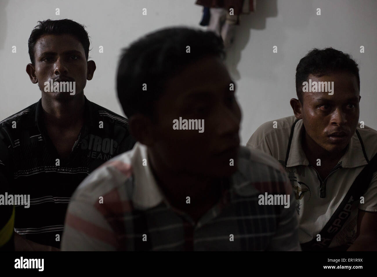 Langkawi, Malaysia. 20th May, 2015. Rohingya men gathered inside an abandoned building, after their end of work day.Norbashoor (left), he's 19 years old and he arrived here in Langkawi 1 year ago.Sabri Halam (middle), he's 20 years old and he's the brother of Mohamad Robil Alam.Muhammad Basin (right), he's 22 years old and he arrived here in Langkawi 7 month ago, he has no ID card or UN card.In Kuah district, not too far from the touristic area of Langkawi Island, and close from the airport.9 Rohingyas men aged between 15 and 26 years old, share a flat inside an abandoned building owned b Stock Photo