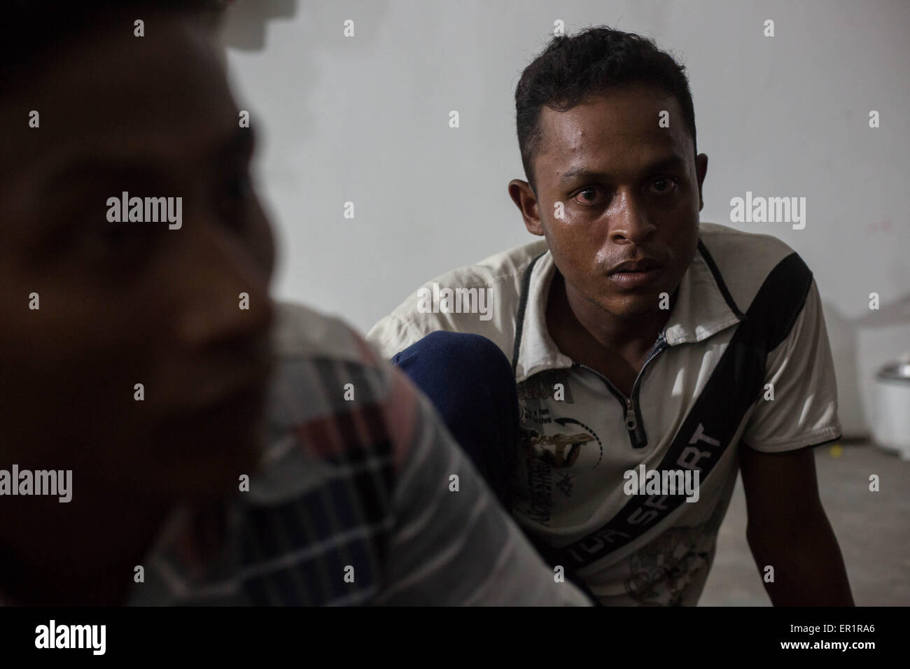 Langkawi, Malaysia. 20th May, 2015. Rohingya men gathered inside an abandoned building, after their end of work day.Muhammad Basin (right), he's 22 years old and he arrived here in Langkawi 7 month ago, he have no ID card or UN card.Sabri Halam (left), he's 20 years old and he's the brother of Mohamad Robil Alam.In Kuah district, not too far from the touristic area of Langkawi Island, and close from the airport.9 Rohingyas men aged between 15 and 26 years old, share a flat inside an abandoned building owned by their employer which they work for.After fleeing their own country (Myanmar) ' Stock Photo