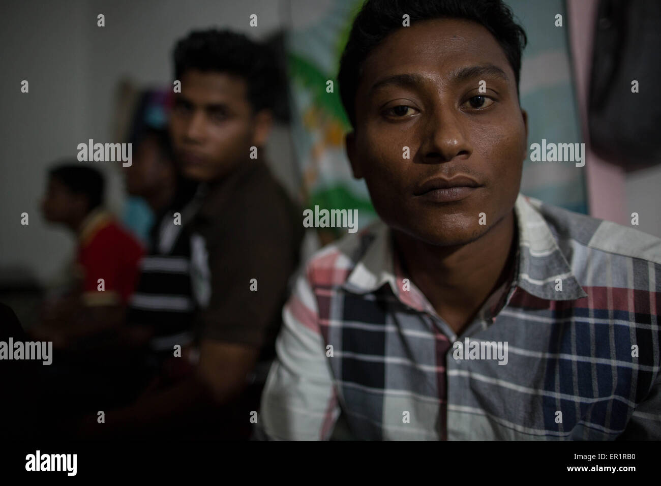 Langkawi, Malaysia. 20th May, 2015. Rohingya men gathered inside an abandoned building, after their end of work day.Sabri Halam (right), he's 20 years old and he's the brother of Mohamad Robil Alam.In Kuah district, not too far from the touristic area of Langkawi Island, and close from the airport.9 Rohingyas men aged between 15 and 26 years old, share a flat inside an abandoned building owned by their employer which they work for.After fleeing their own country (Myanmar) ''helped'' by smugglers usually from Thailand, and spending for some of them more than 10 months traveling by boat, or Stock Photo