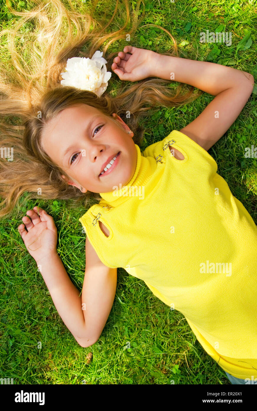 Happy young girl lying on a green grass Stock Photo - Alamy