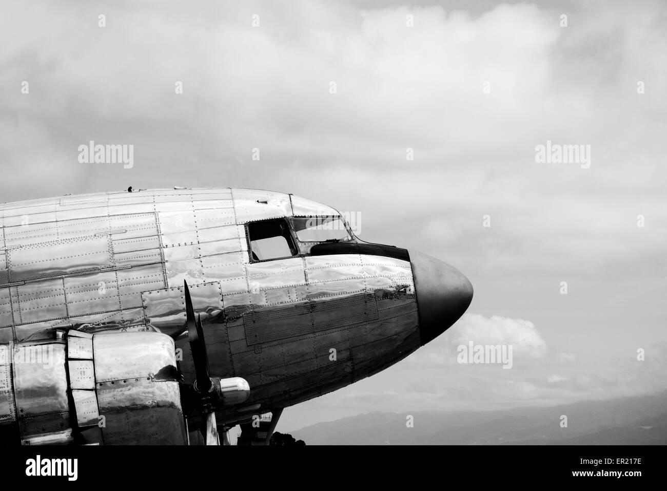 Classic Douglas DC-3 C-47 airliner aircraft front fuselage in black and white against a cloudy sky Stock Photo