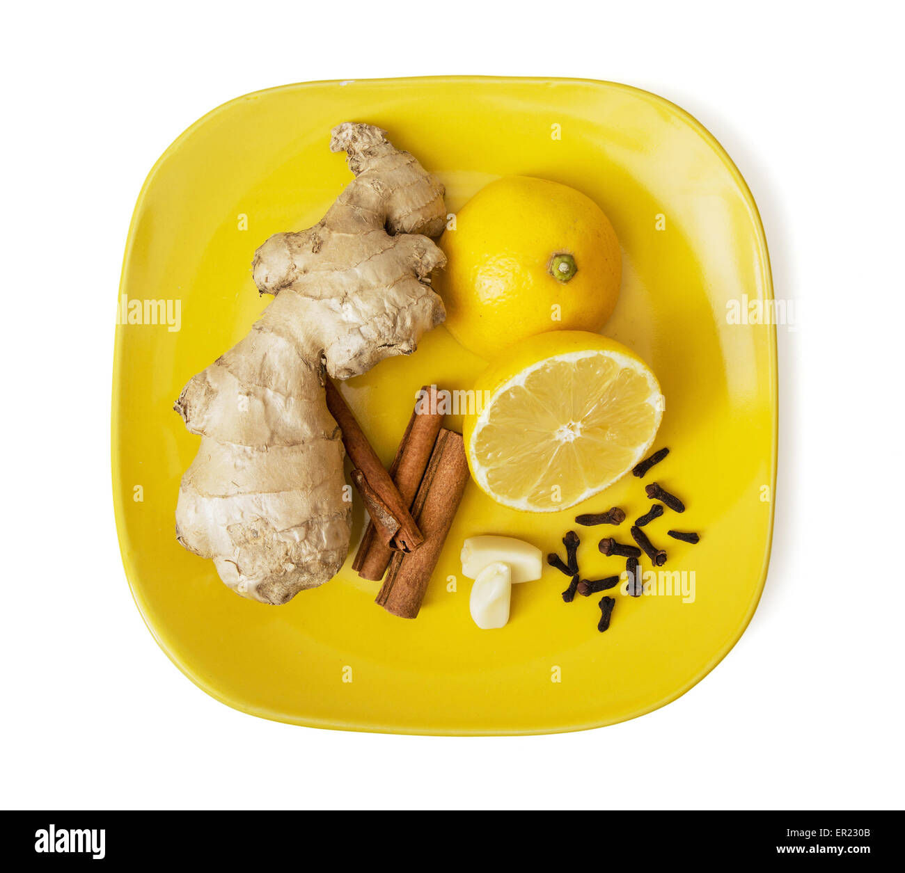 Ginger, cinnamon, lemon, garlic and cloves on the plate. Healthy food