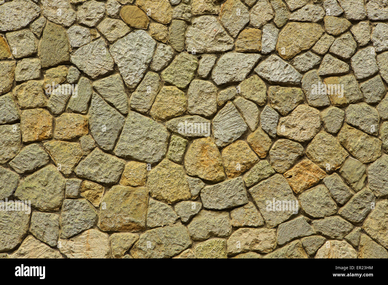 Sandstone blocks forming a useful background. A textured wall of different coloured stone blocks in a random pattern Stock Photo