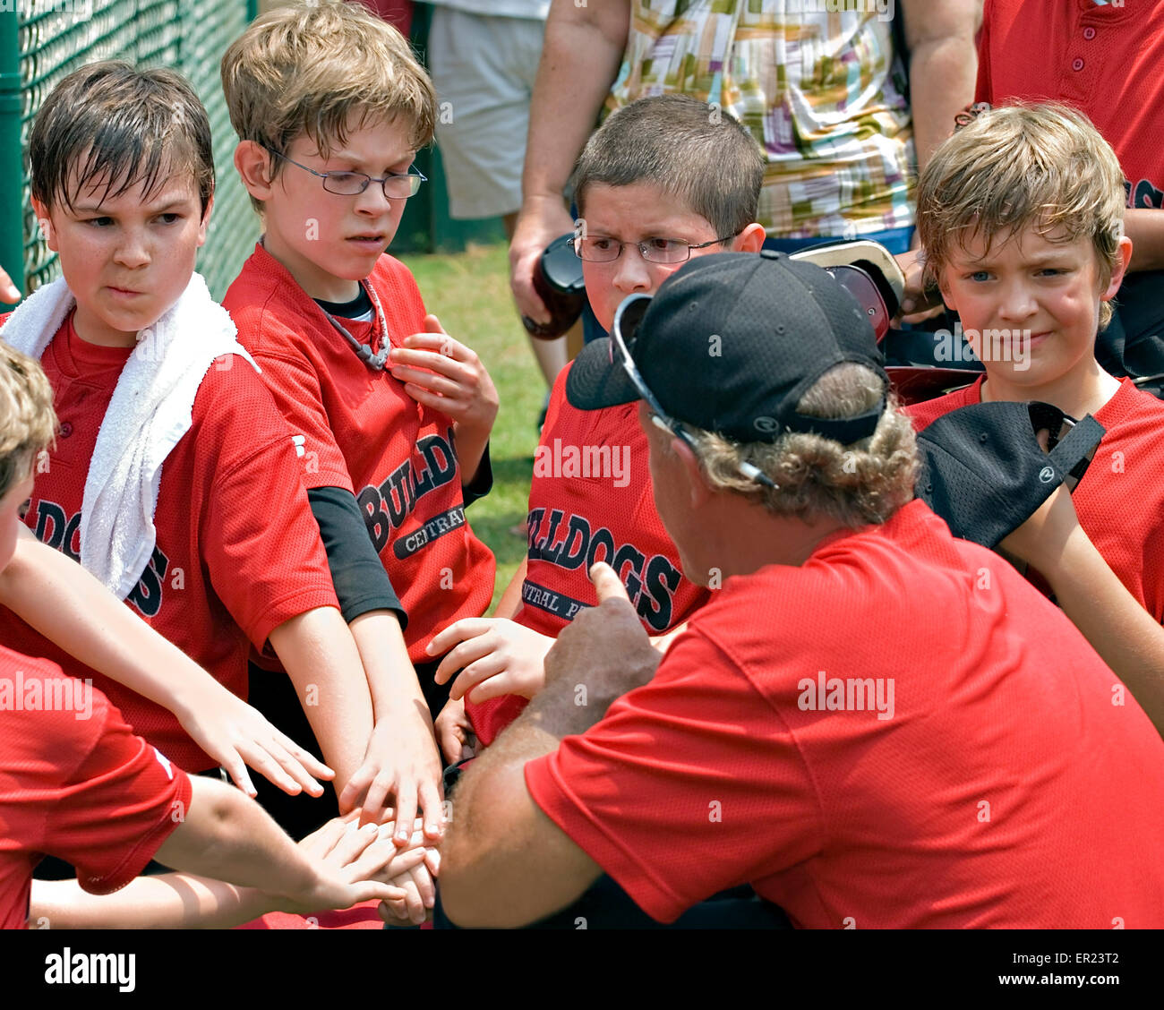 A coach giving a pep talk to his baseball team of 10-11 year old boys before the game begins, Stock Photo