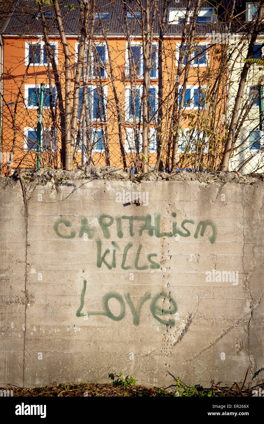 Europa, Deutschland, Nordrhein-Westfalen, Koeln, Graffiti Kapitalismus toetet die Liebe an einer Mauer an Deutzer Rheinufer.  Eu Stock Photo