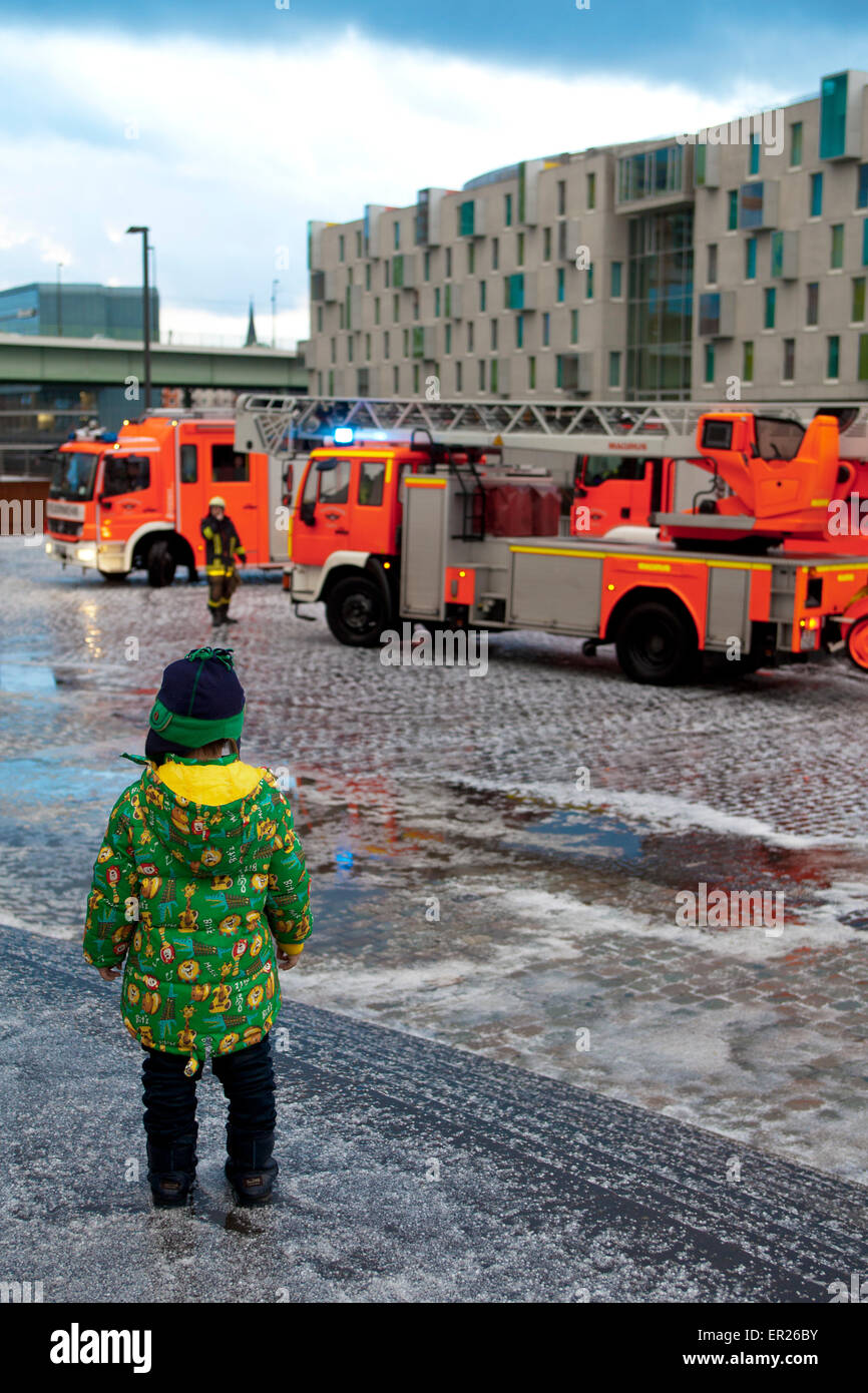 Europa, Deutschland, Nordrhein-Westfalen, Koeln, Feuerwehreinsatz im Koelner Rheinauhafen nach einem Gewitter, Junge schaut zu.  Stock Photo