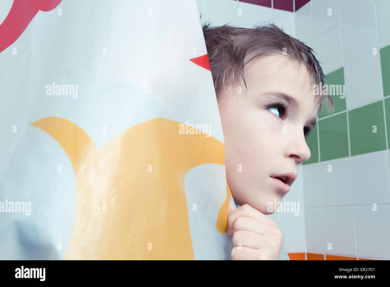 boy 8 years behind shower curtain Stock Photo