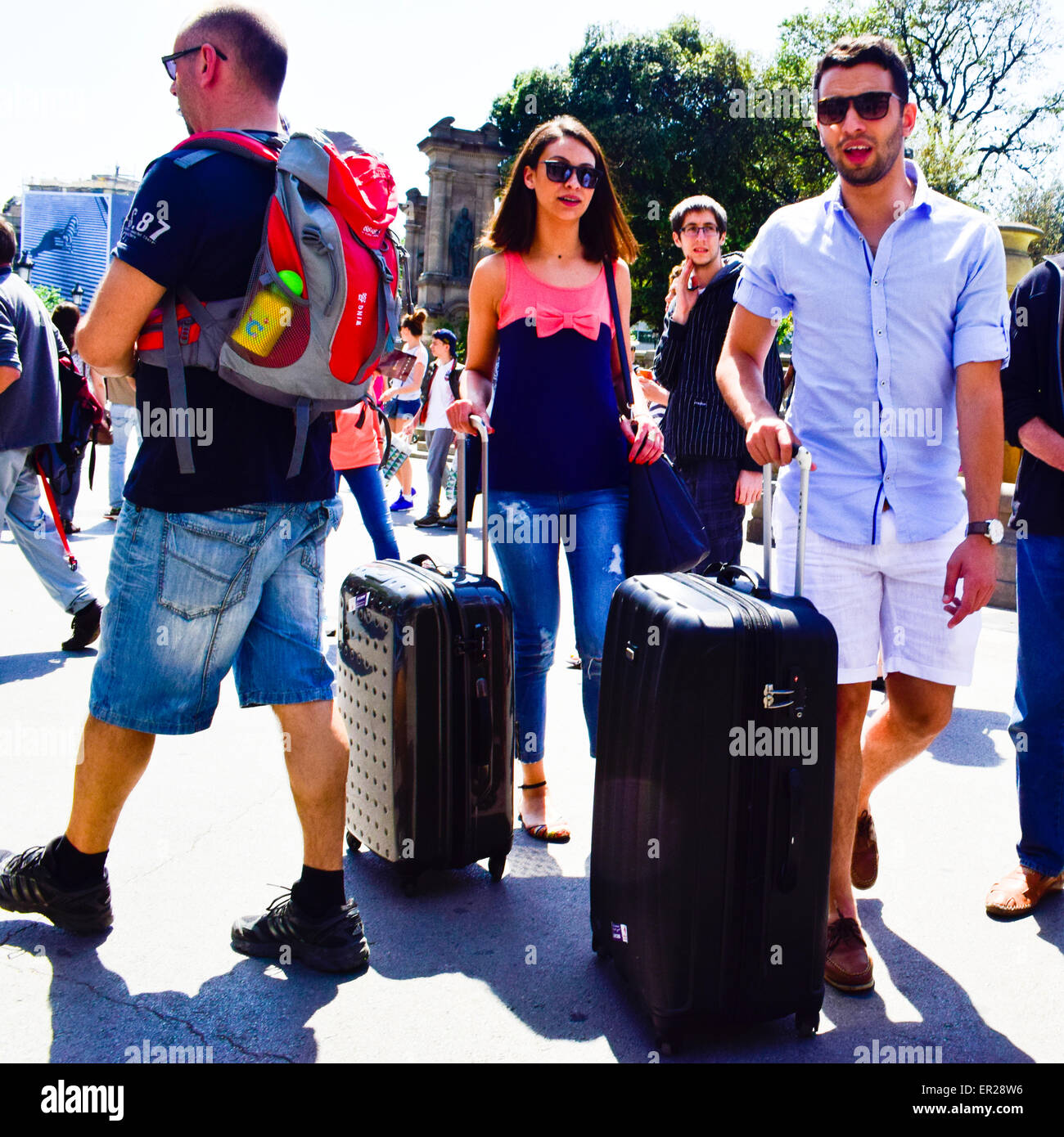 Couple walking with their wheeled suitcase. Barcelona, Catalonia, Spain. Stock Photo