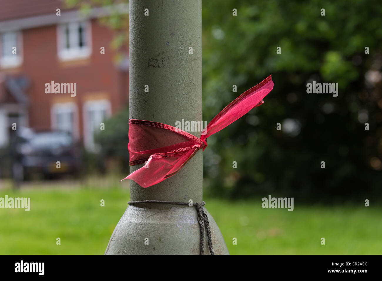 Didcot, Oxfordshire, UK. 25th May, 2015. Red ribbons tied to lamp posts /street lights around Didcot in memory of Mr Howard, Ms Jordon and 6 year old Derin. Credit:  NiKreative/Alamy Live News Stock Photo