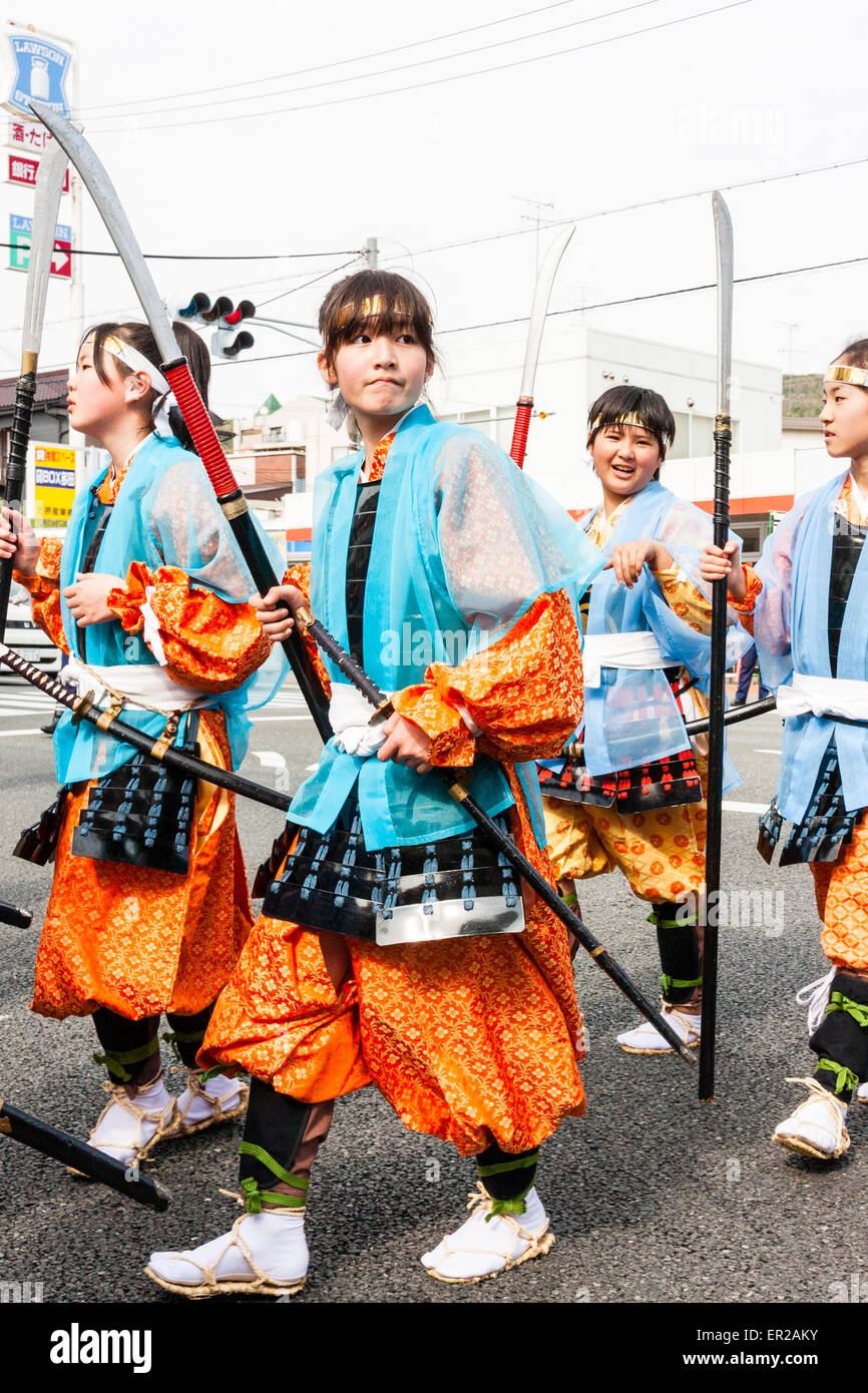 Team of children, girls, marching dressed up as Heian era shimobe soldiers in the springtime Genji parade through town street at Tada, Japan. Stock Photo