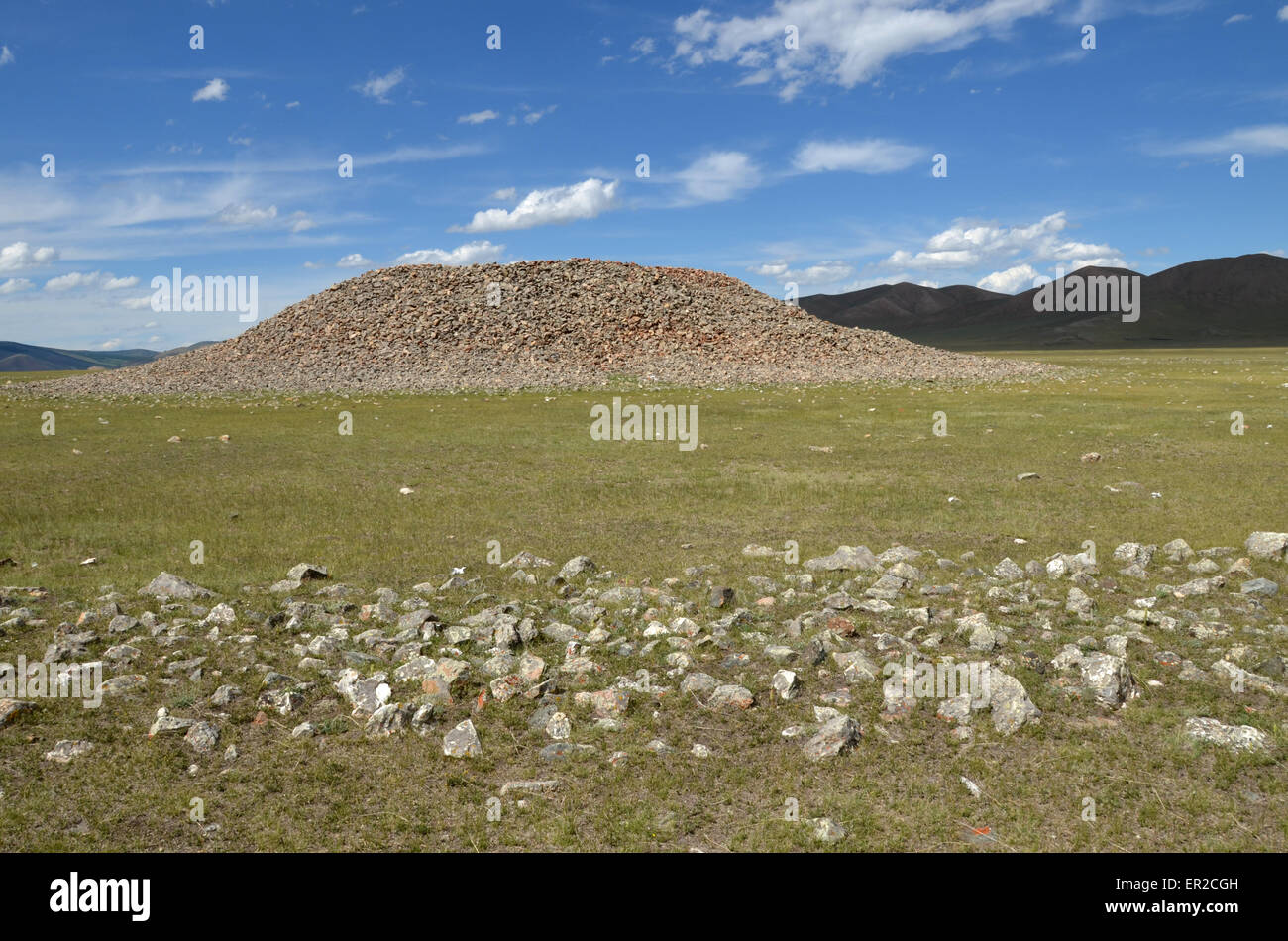 A burial mound in the Arhangay province, central Mongolia. In the foreground is a stone circle around the monument. Stock Photo