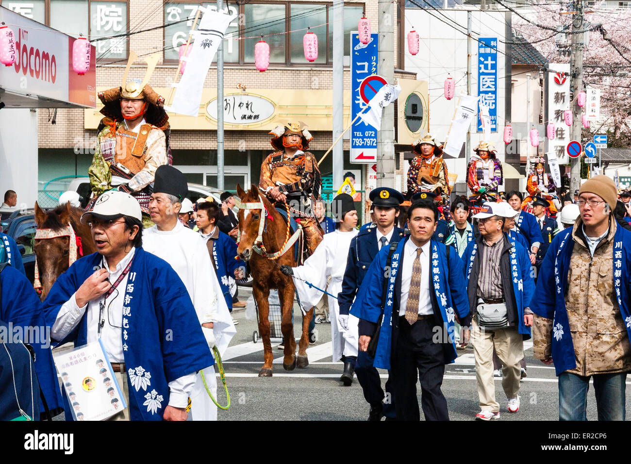 The springtime annual Genji parade in Tada, Japan. Stewards marching with Heian courtiers and mounted samurai warriors through city street. Stock Photo