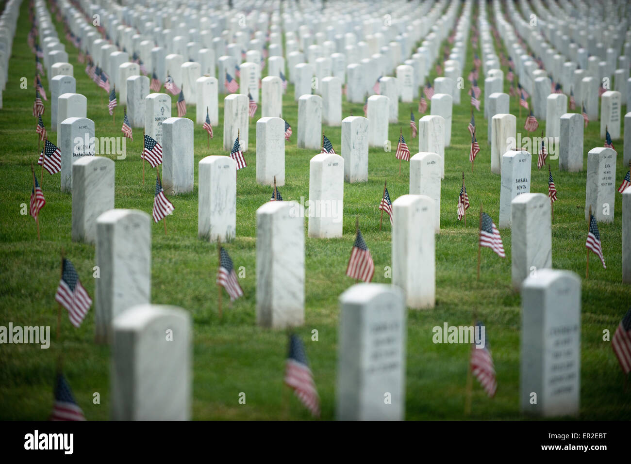 U.S. flags in front of grave sites in honor of Memorial Day at Arlington National Cemetery May 21, 2015 in Arlington, Virginia. The Old Guard has conducted Flags-in, when an American flag is placed at every headstone, since 1948. Stock Photo
