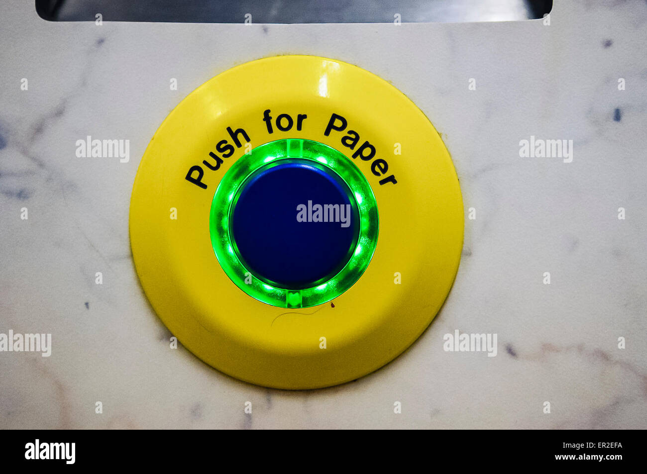 Button marked 'Push for paper' in an automatic public toilet. Stock Photo
