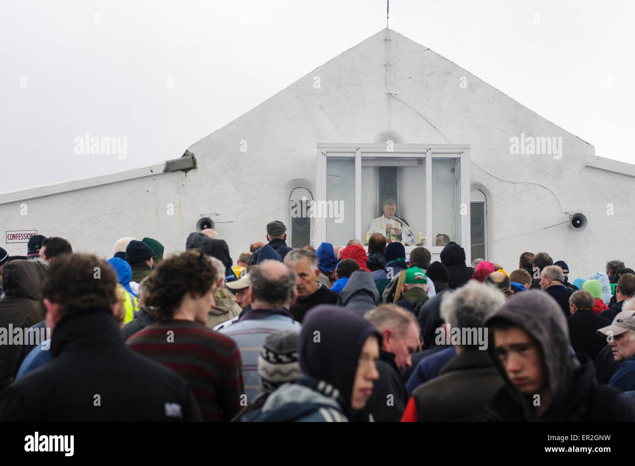 Pilgrims gather at St. Patrick's Chapel at the top of Croagh Patrick for mass during Reek Sunday. Stock Photo