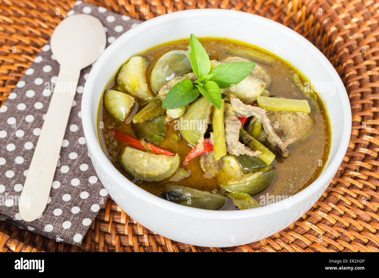 Green curry with meat and eggplants in white bowl. Stock Photo