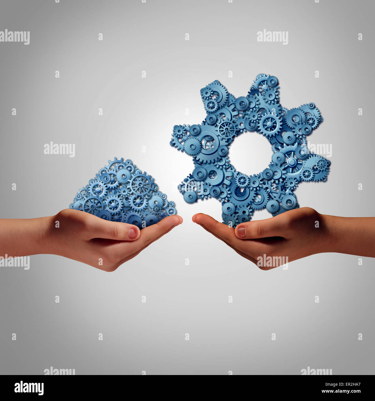 Technology management concept as a hand holding a group of mixed disorganized gears and cogs with another person presenting the Stock Photo