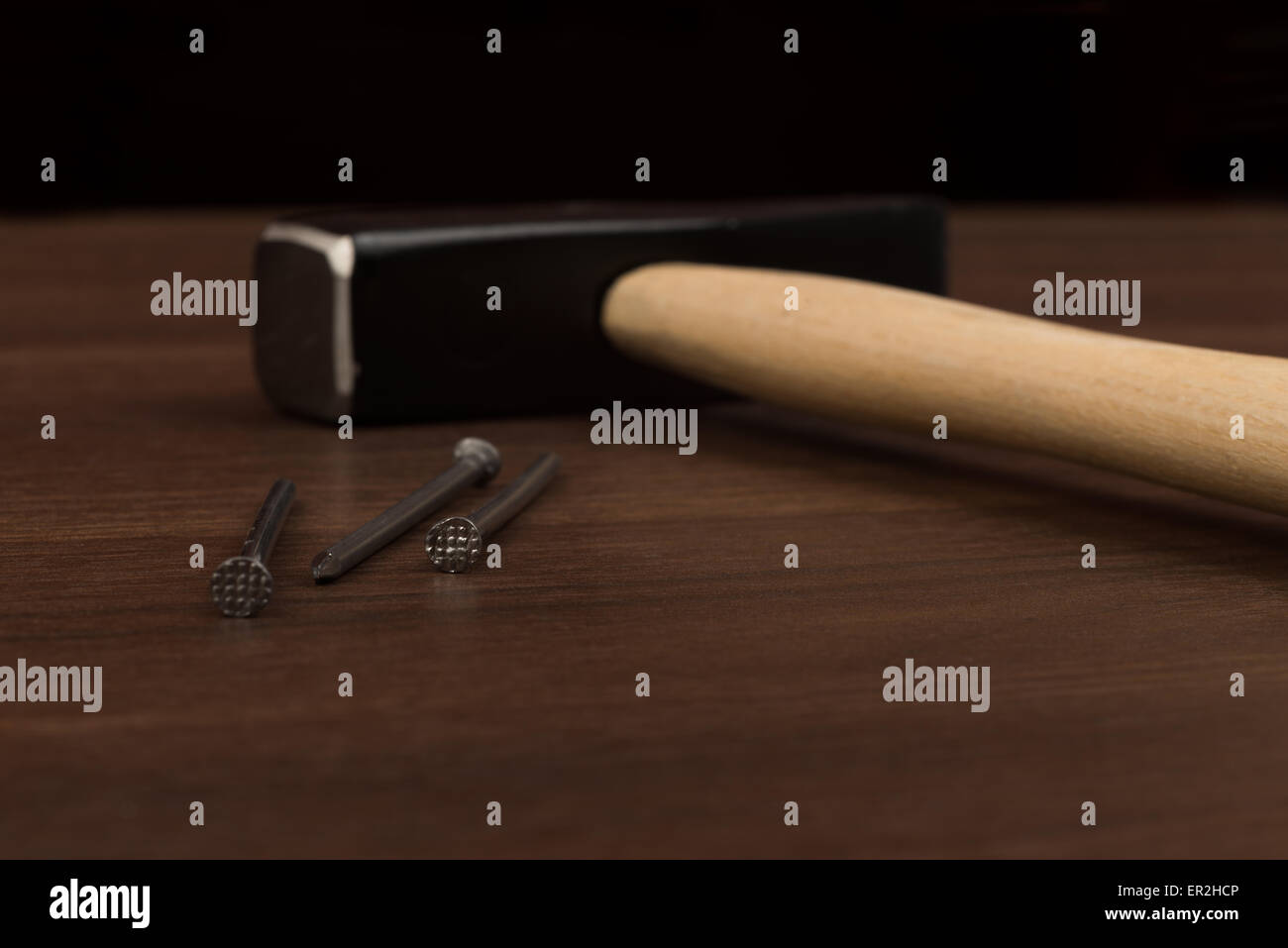 Hammer and three nails on table Stock Photo Alamy