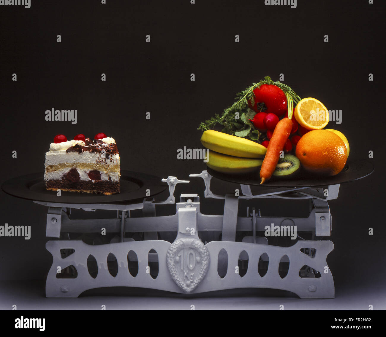 Waage mit Tortenstück und Obst, Symbolfoto Diät Stock Photo