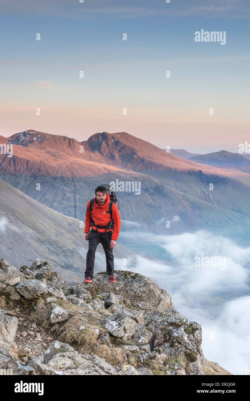 Hiker on Pillar at sunset in the English Lake District, with Mosedale, Scafell and Scafell Pike in the background Stock Photo