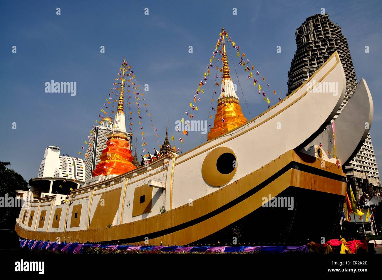 Bangkok, Thailand:  An immense stone boat with two silk encased white chedis topped by gold spires at Wat Yanawa Stock Photo