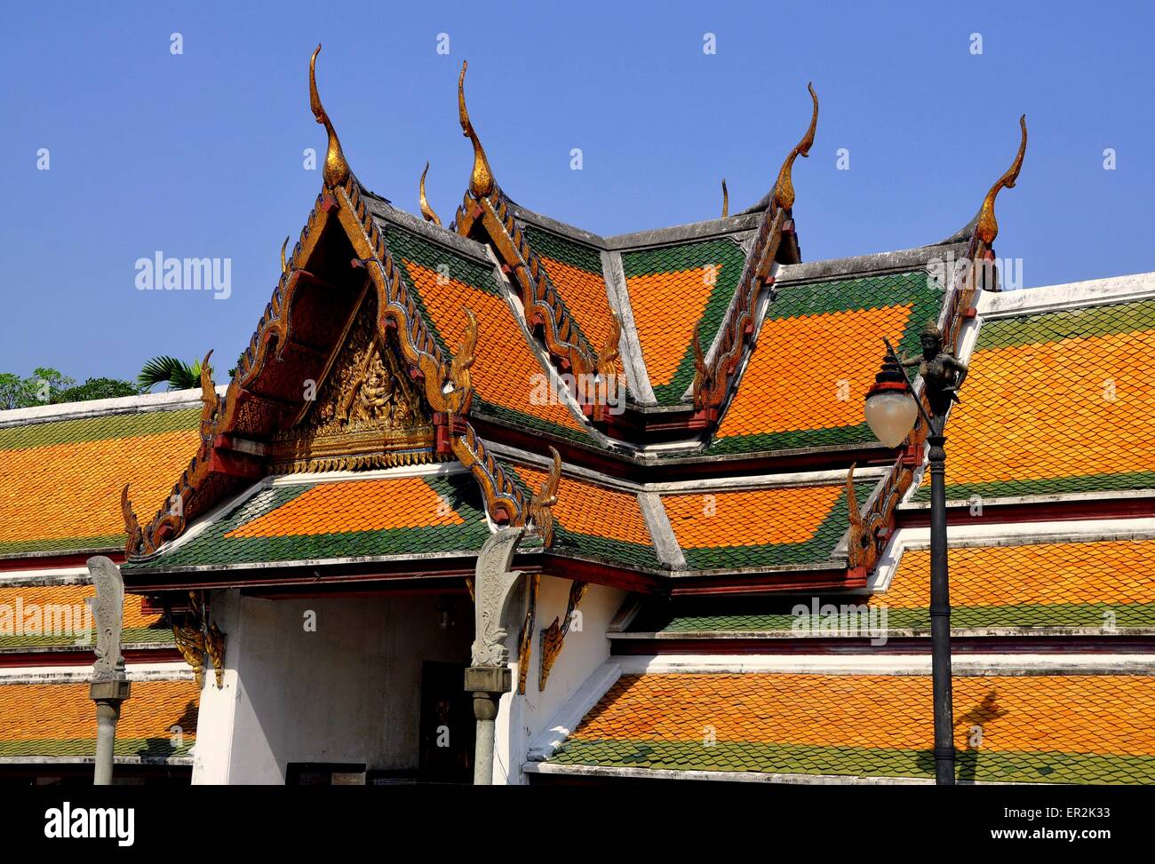 Bangkok, Thailand:  Steeply gabled roofs with gilded chofah ornaments over the cloister gallery at Wat Suthat Stock Photo