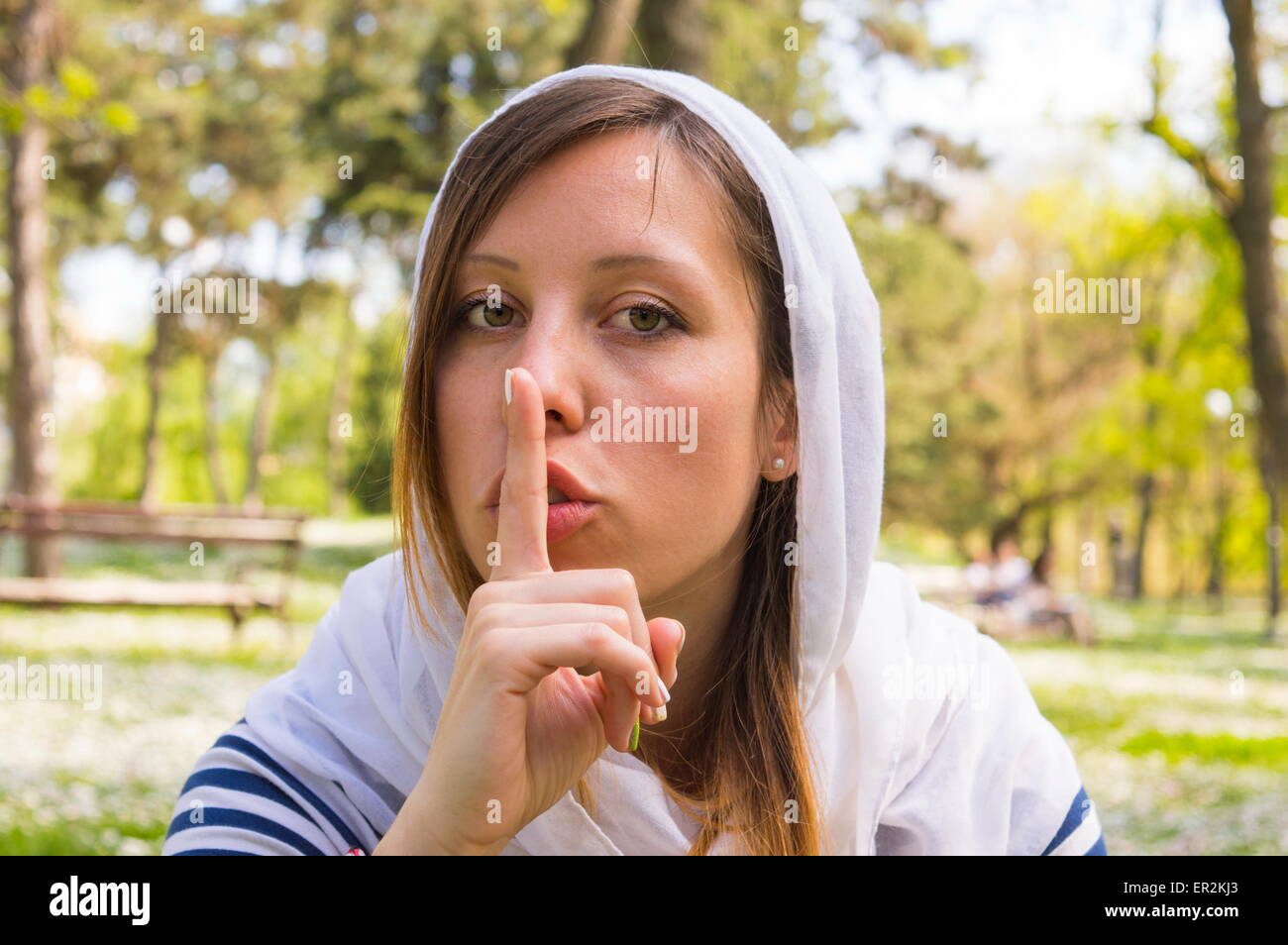 Girl wearing a hood and keeping silent Stock Photo