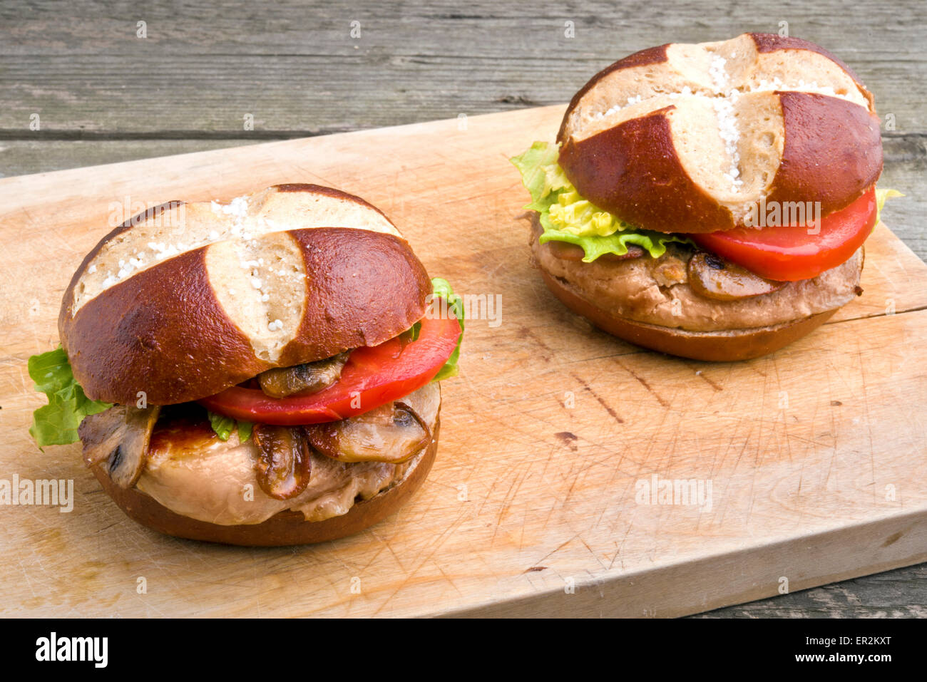 Grilled pork steak sandwich (burger) with mushrooms in pretzel style lye roll Stock Photo
