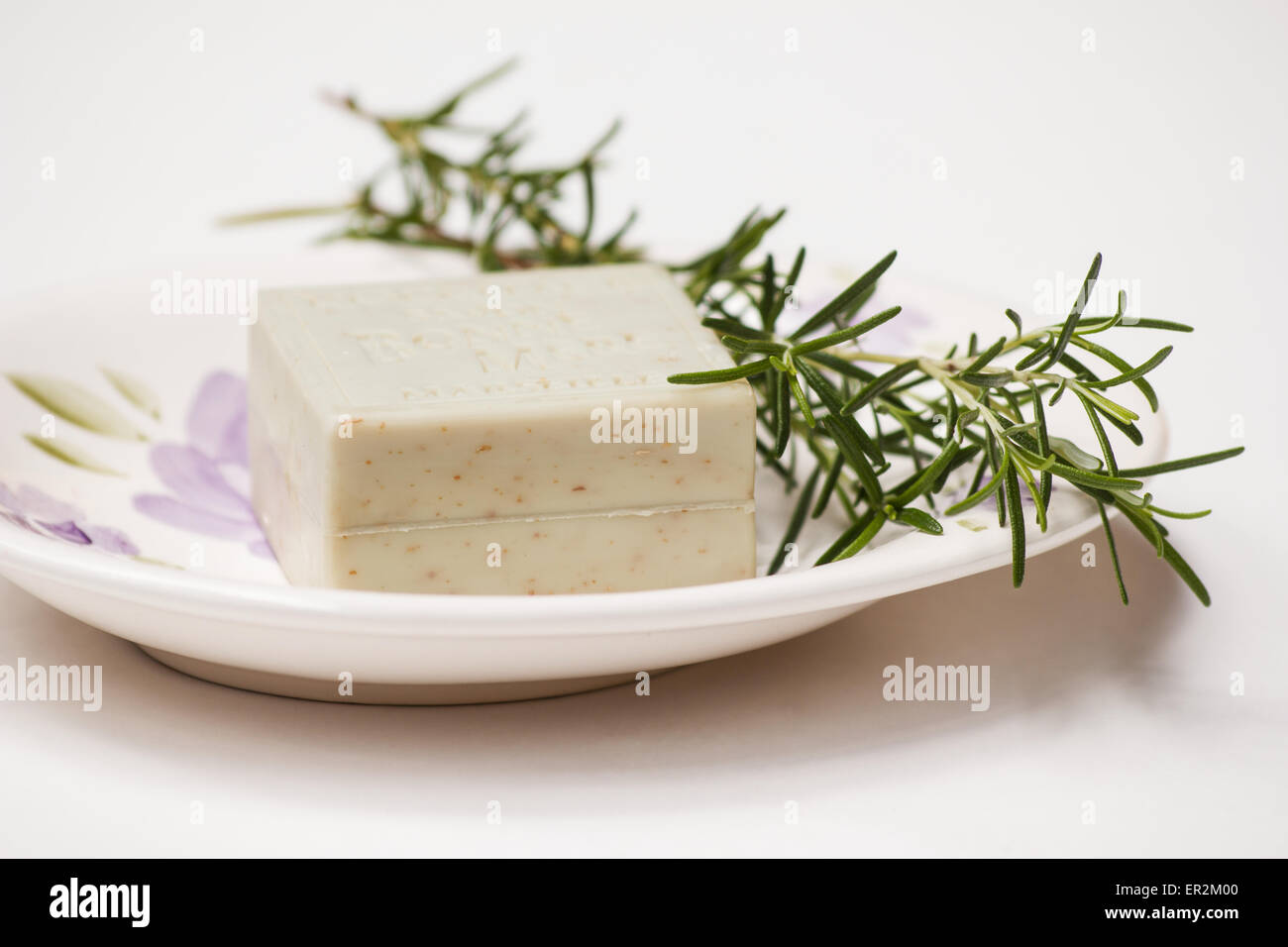 Rosemary sprigs with soap in soap dish still life on white background Stock Photo