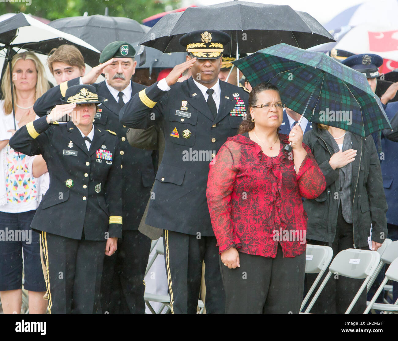 Major Generals Jimmie Keenan (left), Simeon Trombitas (center), and Lawarren Patterson (right) salute the American flag and General Patterson's wife Jule (far right) shows respect at the close of the Memorial Day ceremony at Fort Sam Houston National Cemetery. Stock Photo