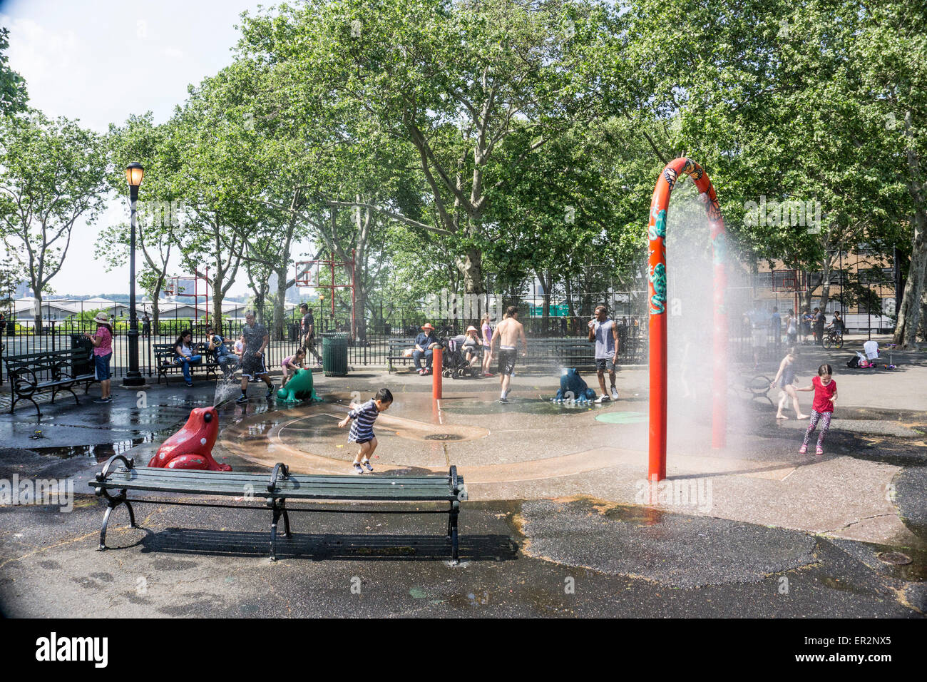 New York City Monday May 25 2015, USA; on a hot Memorial Day grownups watch & kids stay cool runnig under an arch spraying fine veil of water Credit:  Dorothy Alexander/Alamy Live News Stock Photo