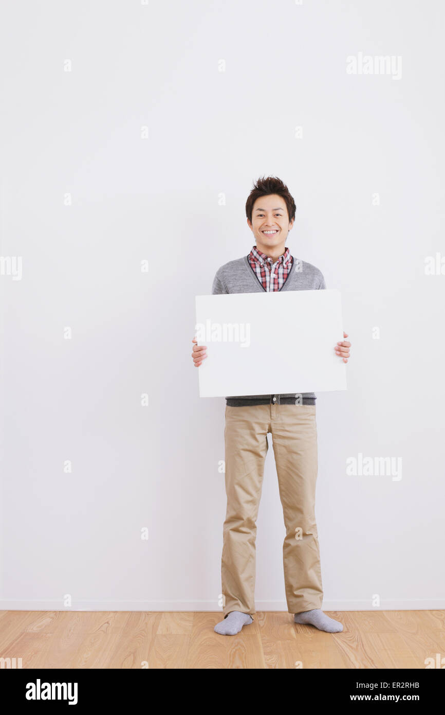 Young adult man standing in front of a white wall with whiteboard Stock ...