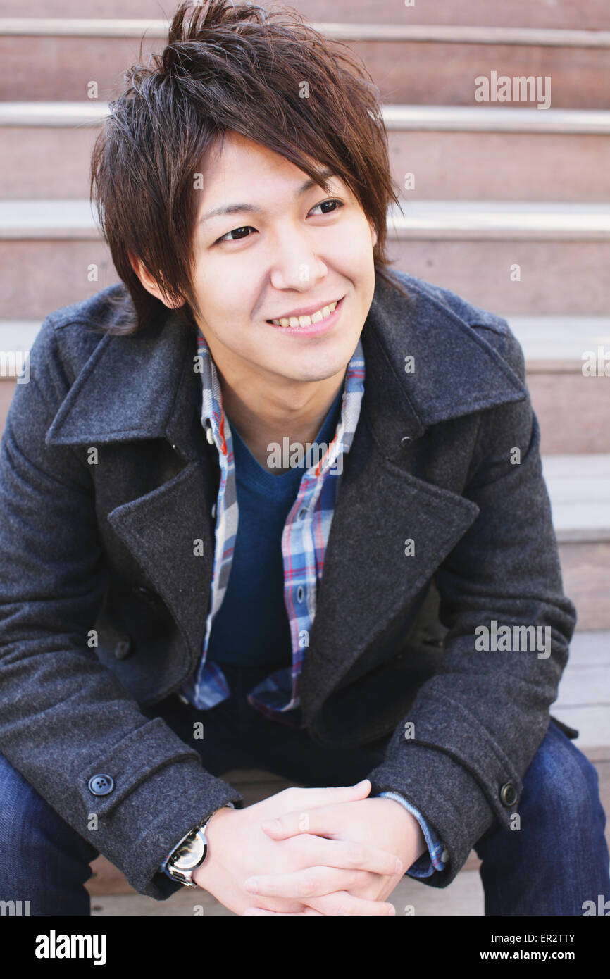 Young man sitting on the stairs Stock Photo - Alamy