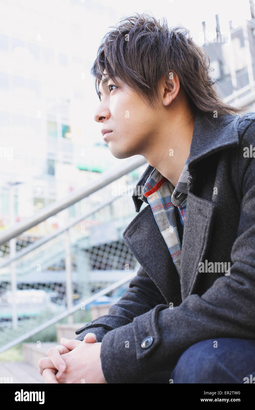 Young man sitting on the stairs Stock Photo - Alamy