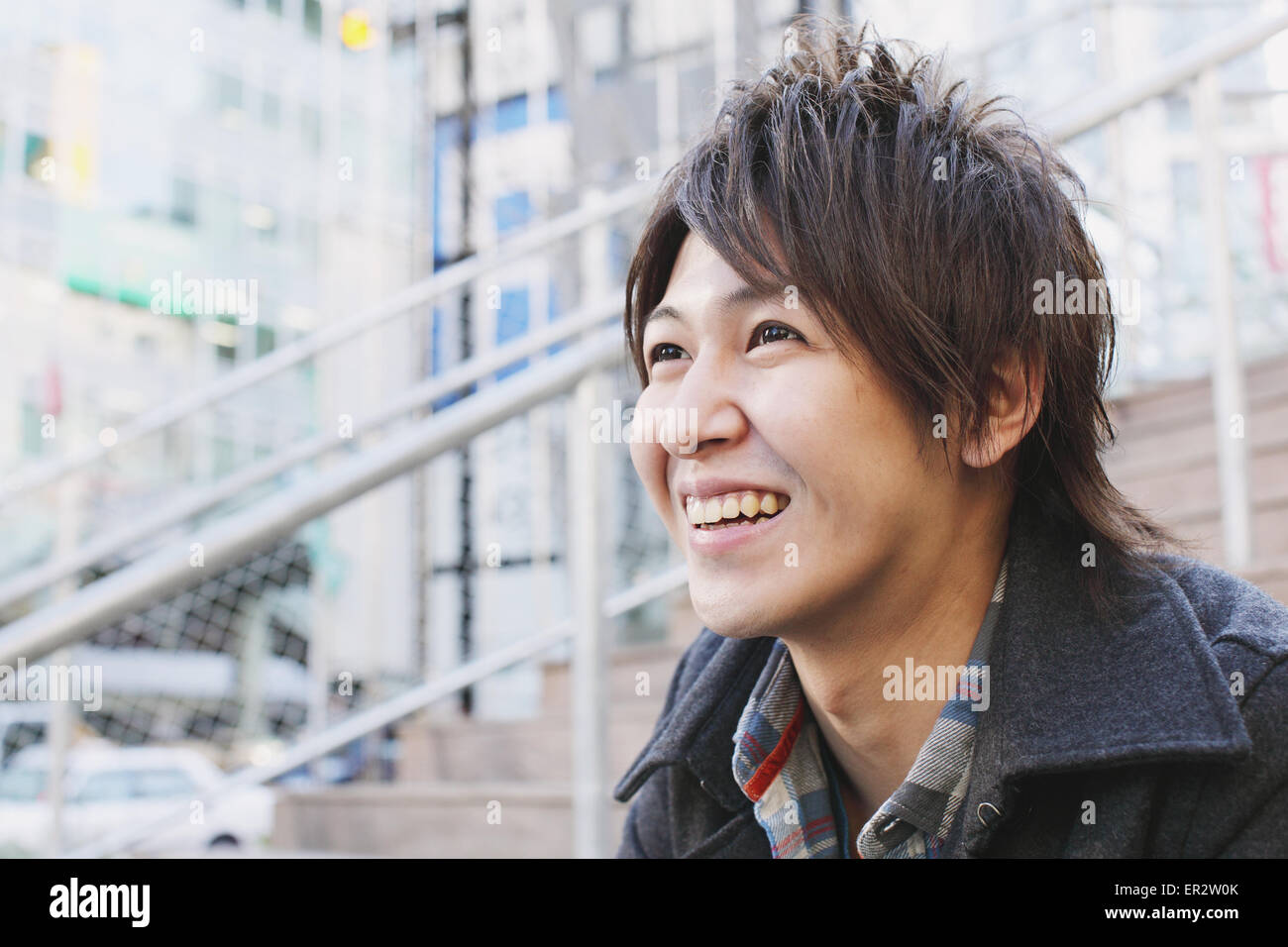 Young man sitting on the stairs Stock Photo - Alamy