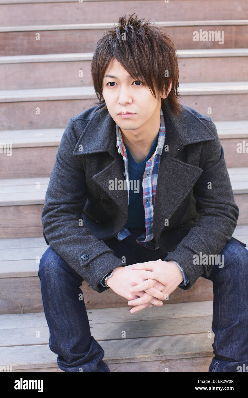 Young man sitting on the stairs Stock Photo - Alamy