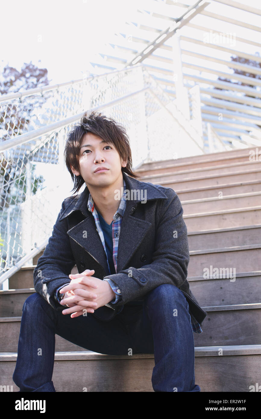 Young man sitting on the stairs Stock Photo - Alamy