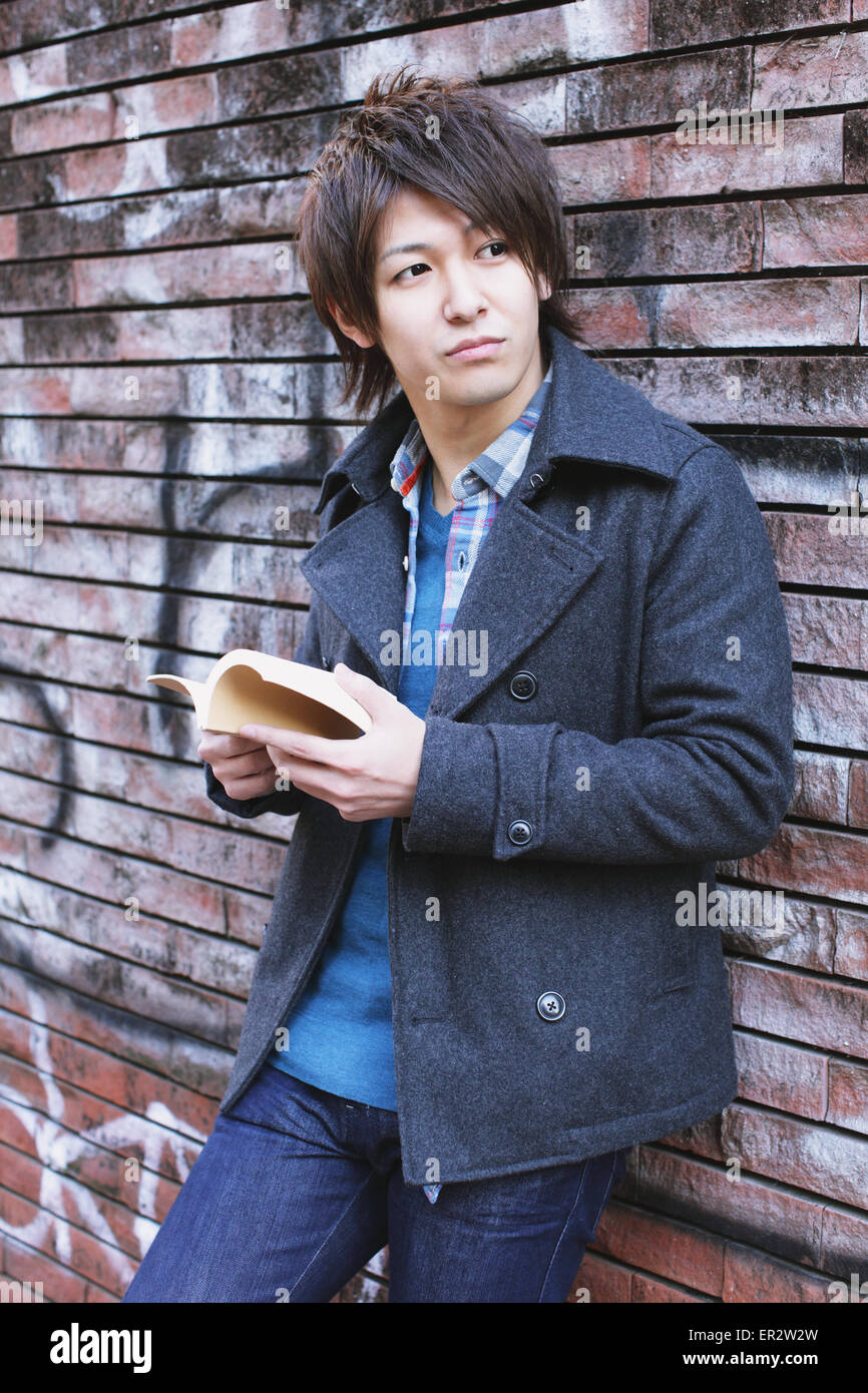 Young man holding a book Stock Photo - Alamy