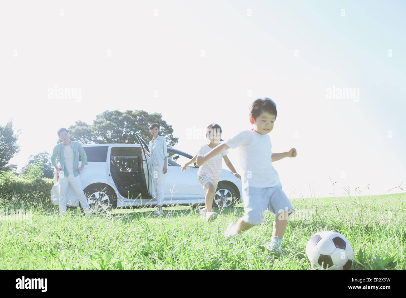 Happy Japanese family with car in a city park Stock Photo