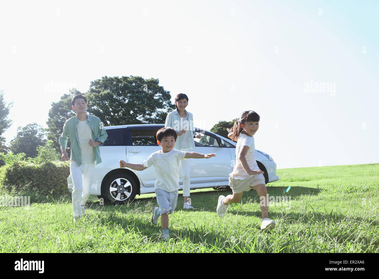 Happy Japanese family with car in a city park Stock Photo