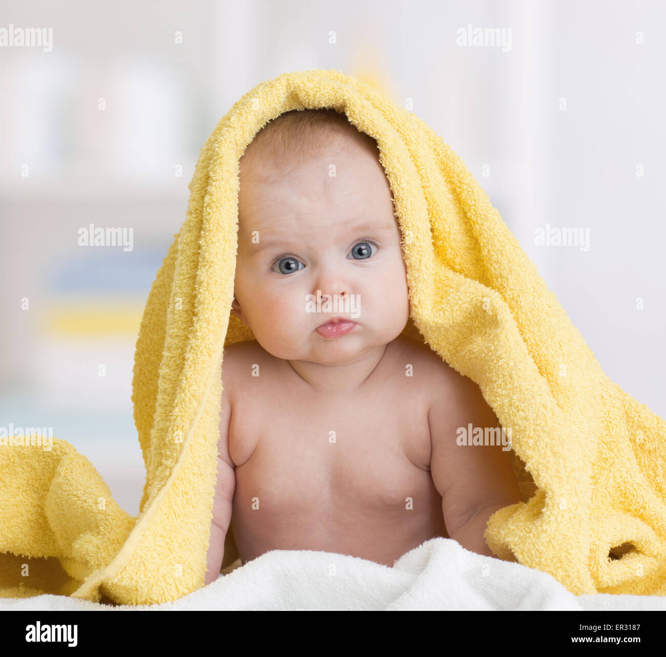 baby girl under towel after bath Stock Photo