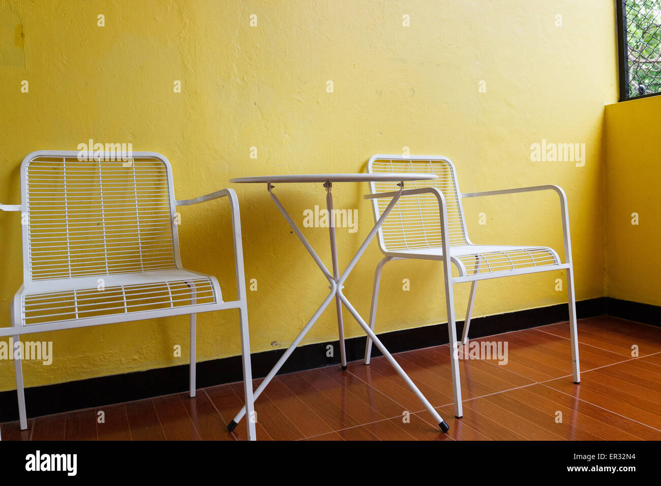 white metal chair and desk with yellow wall Stock Photo Alamy