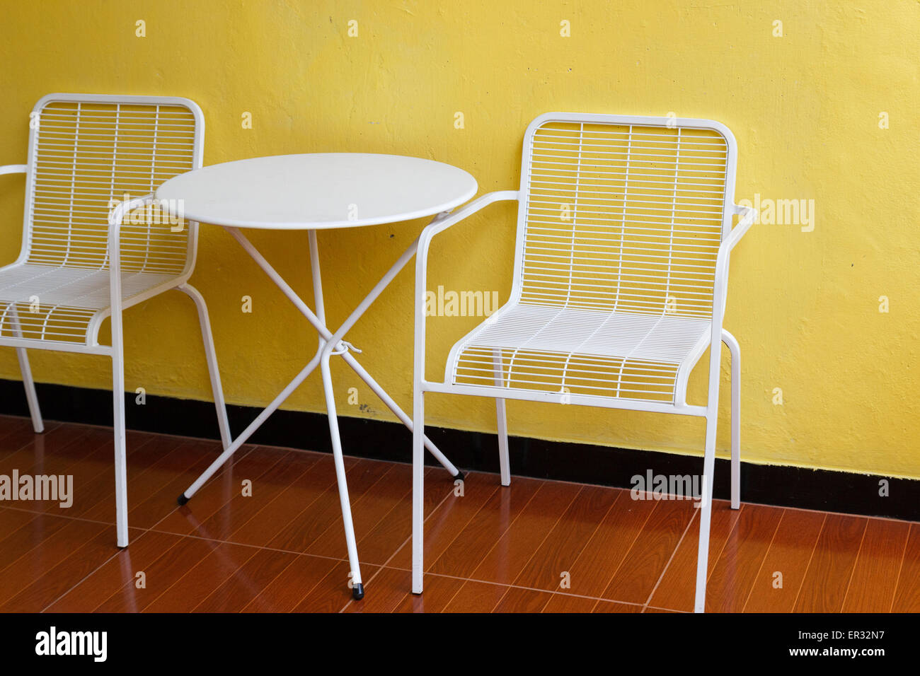 white metal chair and desk with yellow wall Stock Photo Alamy