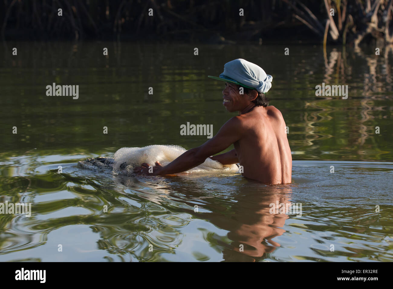 Fisherman In the shallow mud flat waters of Liloan,Cebu Stock Photo